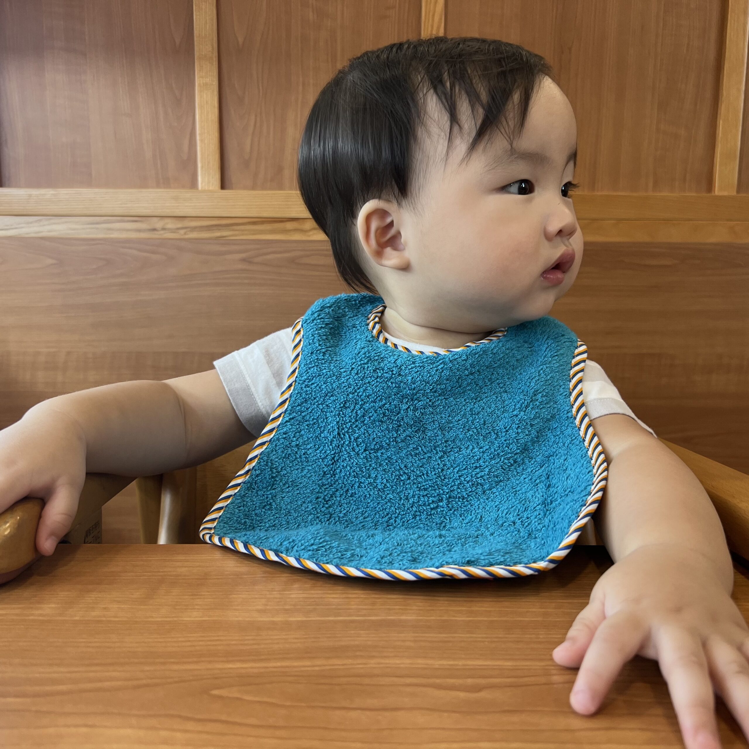 男孩帶著日本今治口水巾在餐廳吃飯